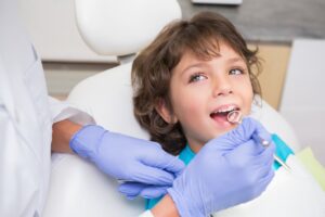 Pediatric dentist examining a little boys teeth