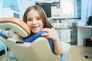 A portrait of a child girl in the cabinet of a dentist. Treatment, medicine, hospital.