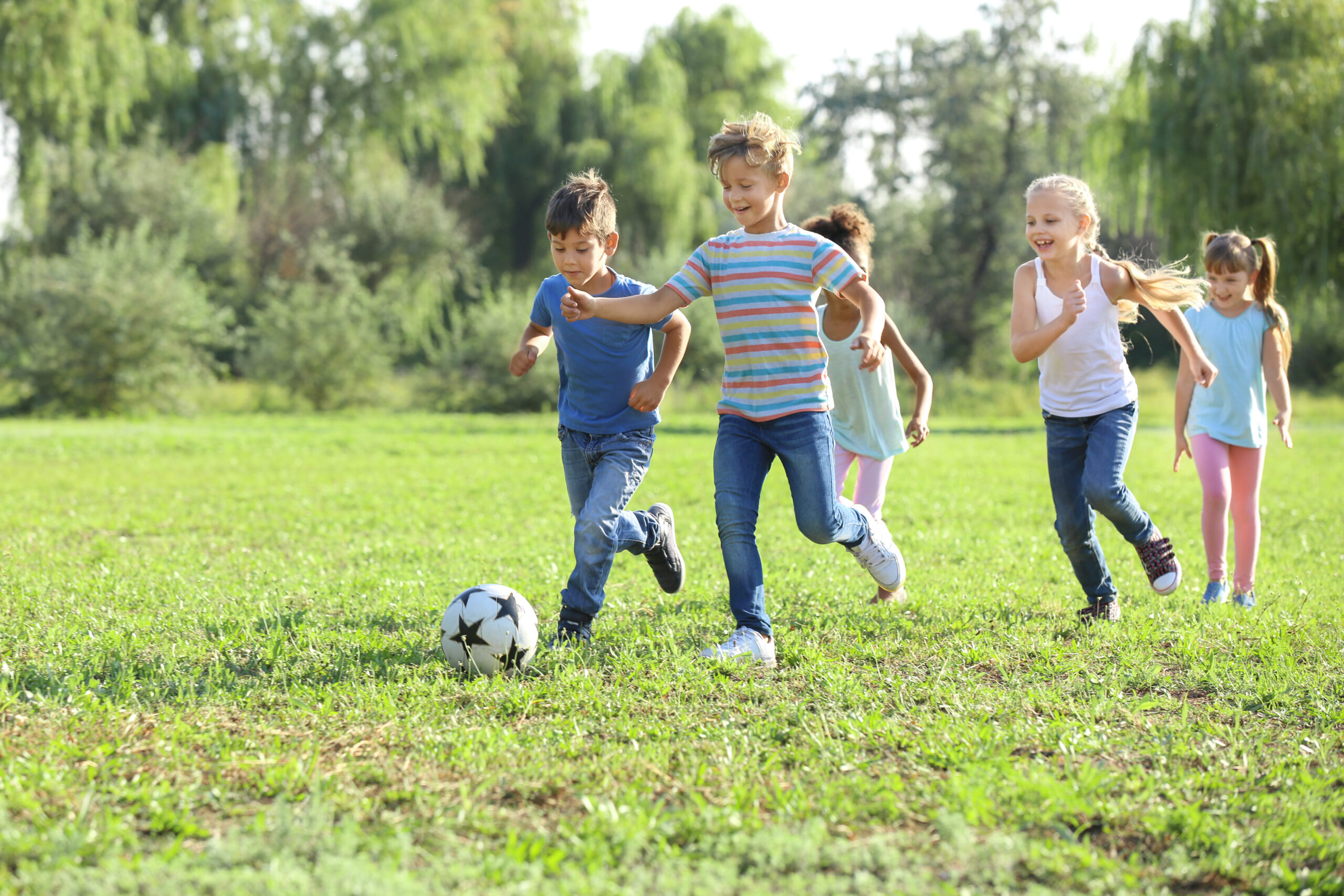 Children playing football outdoors, at risk for common dental injuries in active kids