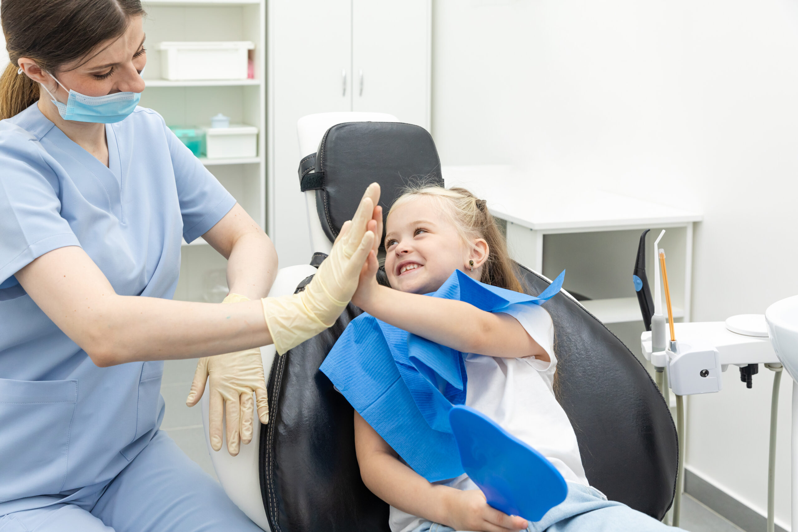 Child giving a high five to a pediatric dentist after dental treatment at Main Street Pediatric Dentistry of Belmont
